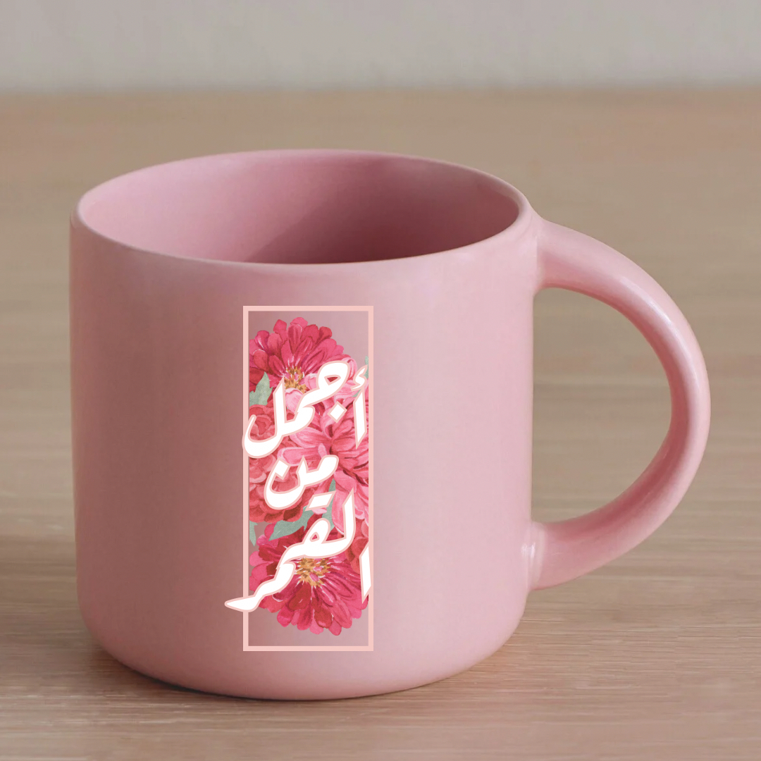 كوب وردي بعبارة أجمل من القمر